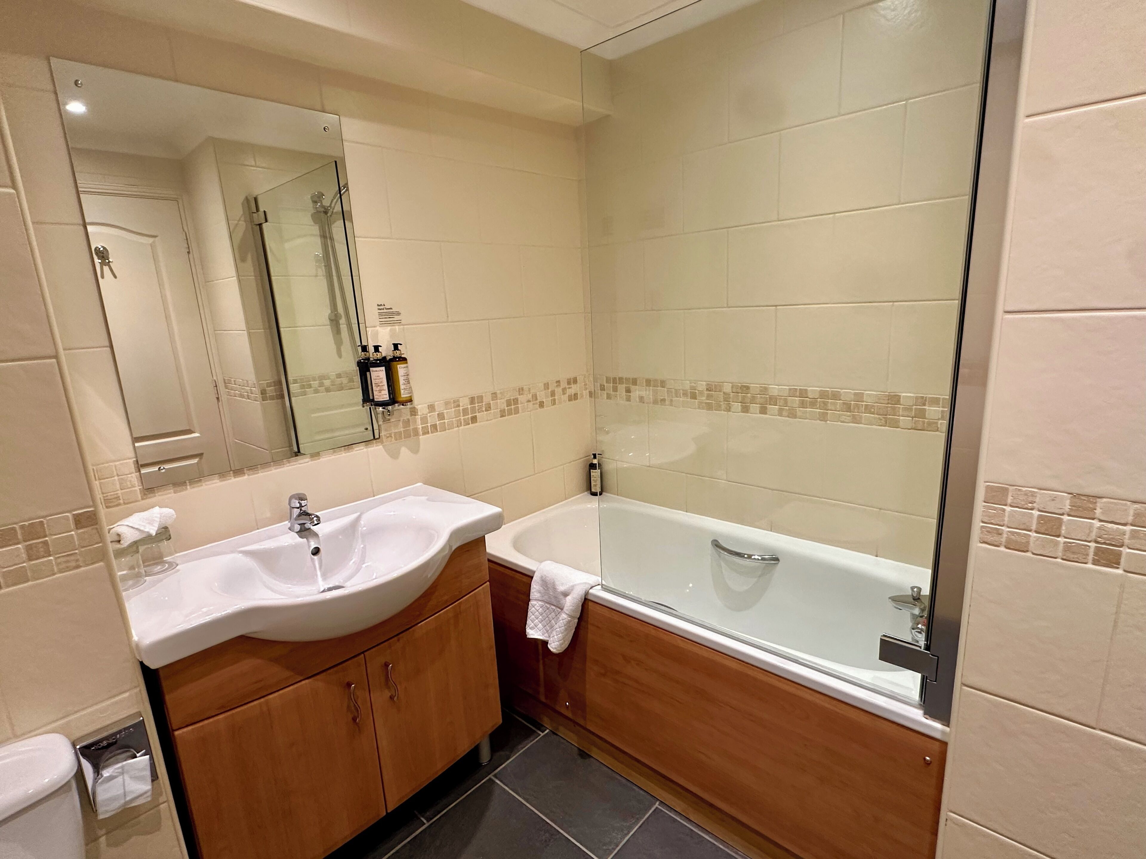 Ein Badezimmer mit zwei Waschbecken, einer Badewanne und einer Duschkabine aus Glas.