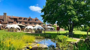 A courtyard with a pond, outdoor seating, and a building in the background. - Stirrups Hotel (Bracknell)