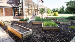 A modern building with large windows and a garden with raised beds. - Stirrups Hotel (Bracknell)