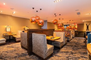 A hotel lobby with seating areas, a reception desk, and decorative lighting. - Sandman Signature Edmonton Downtown Hotel (Edmonton)