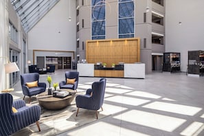 A spacious lobby with seating, a reception desk, and a marketplace. - Crowne Plaza Atlanta NE - Norcross by IHG (Norcross)