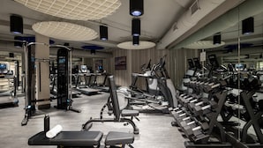 A gym with various exercise equipment, including treadmills, stationary bikes, and weight machines.
