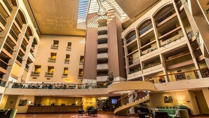 A multi-level hotel lobby with a central atrium, multiple balconies, and a staircase. - Sydney Harbour Hotel (The Rocks)