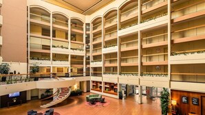 A multi-level atrium with a central staircase, multiple balconies, and seating areas. - Sydney Harbour Hotel (The Rocks)