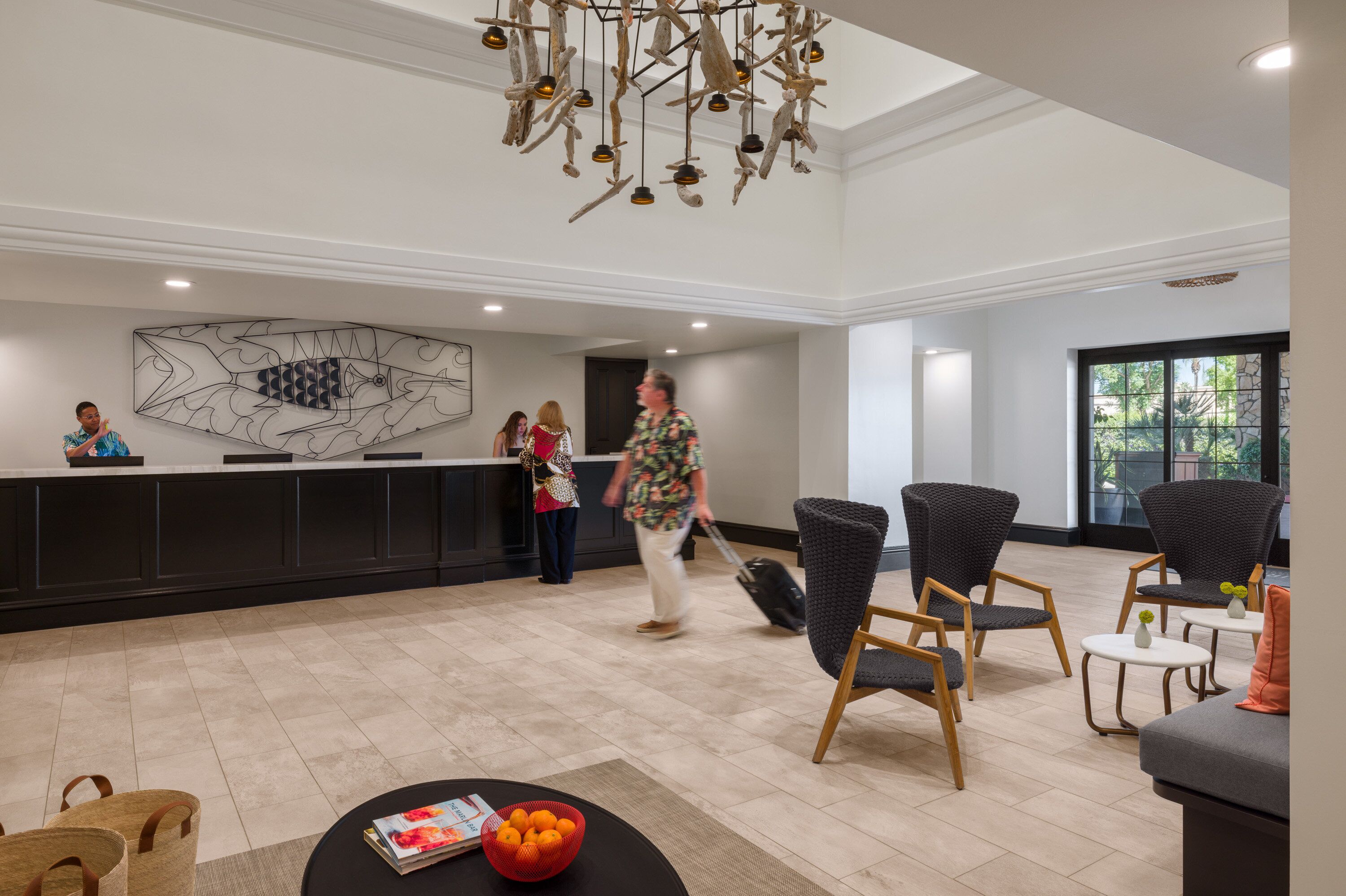 Spaziosa hall con reception, sedie moderne e un lampadario decorativo.