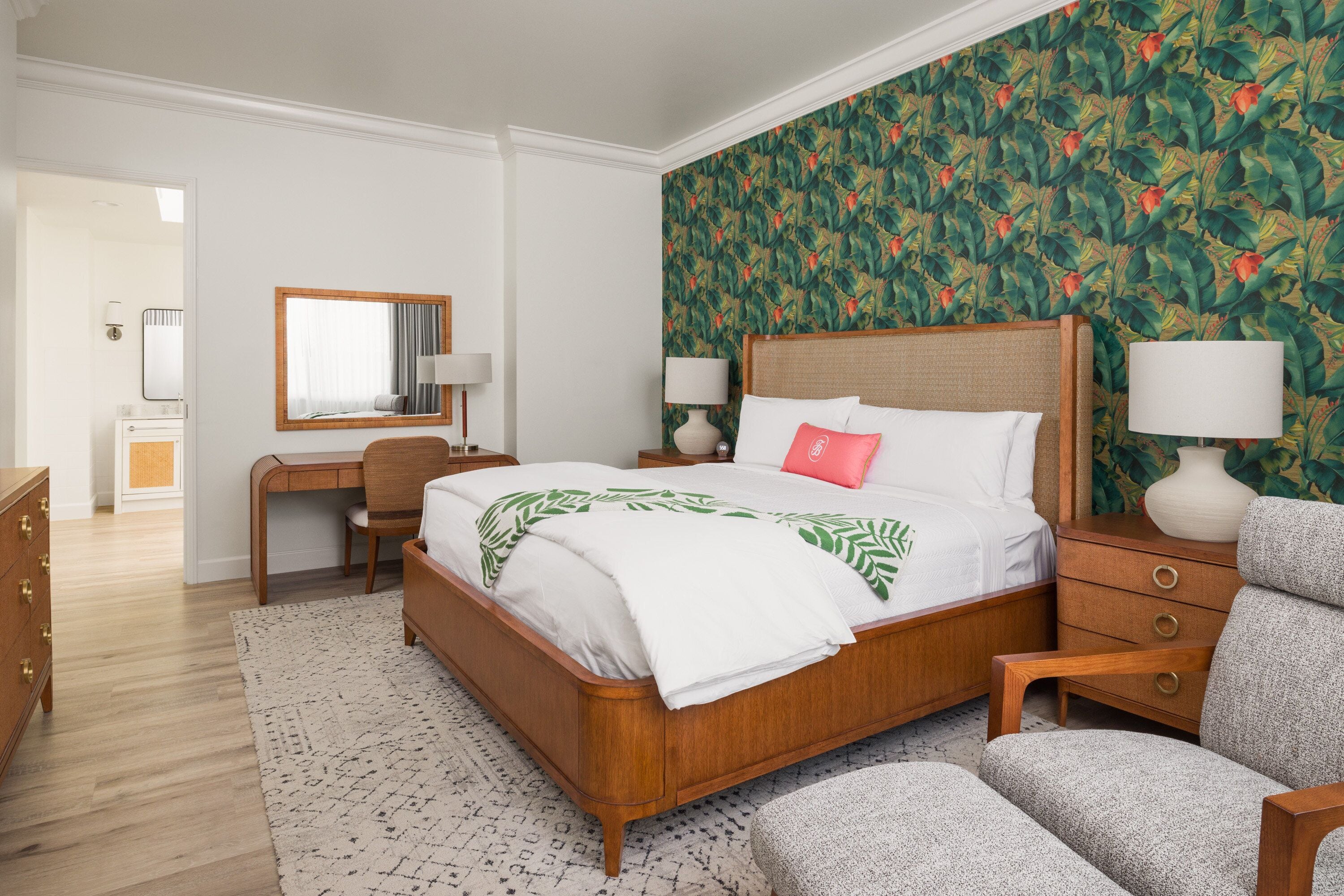 Une chambre à coucher avec un lit en bois, un bureau, une chaise et une table de chevet avec des lampes.