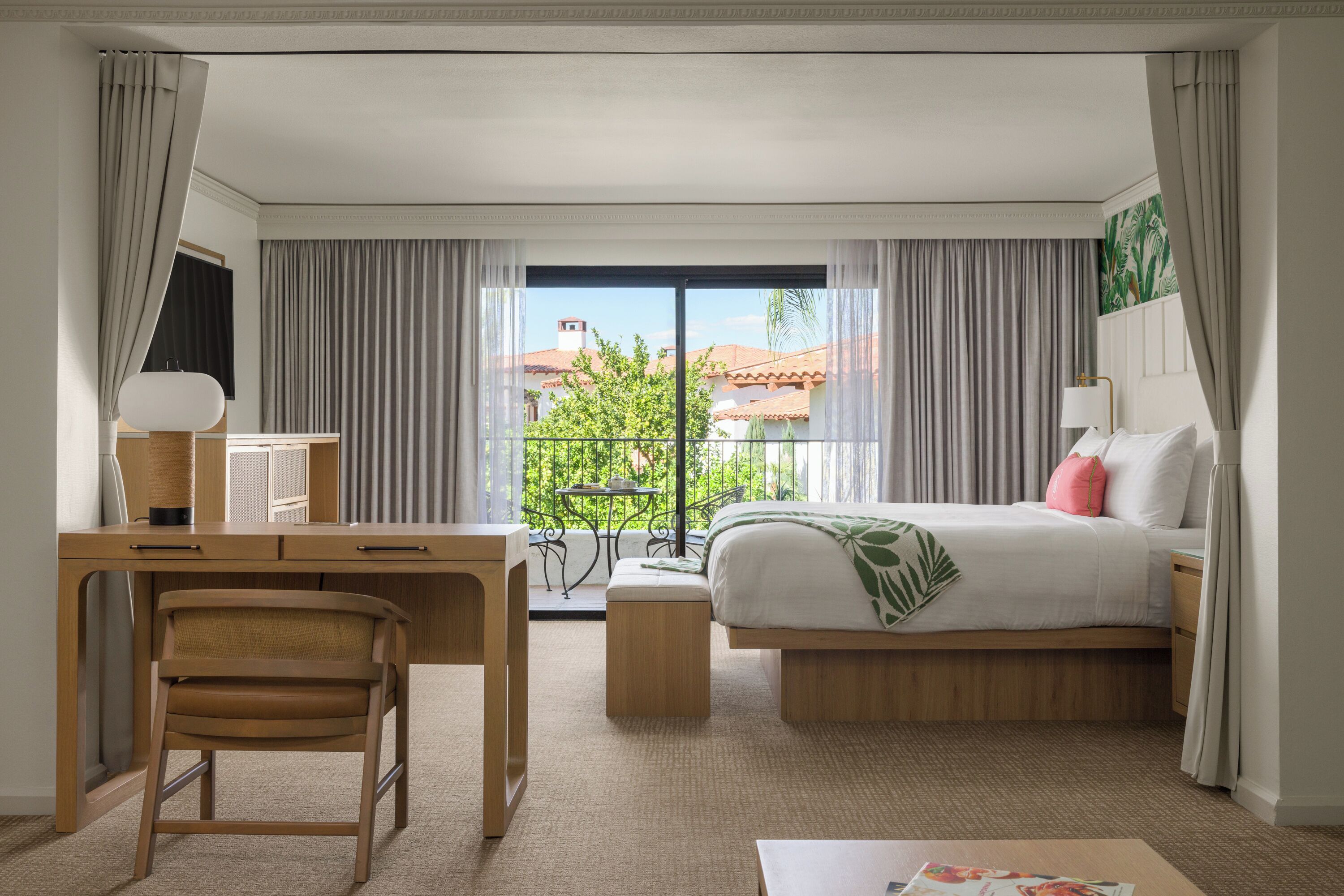 Hotelkamer met een bed, bureau, stoel en uitzicht.