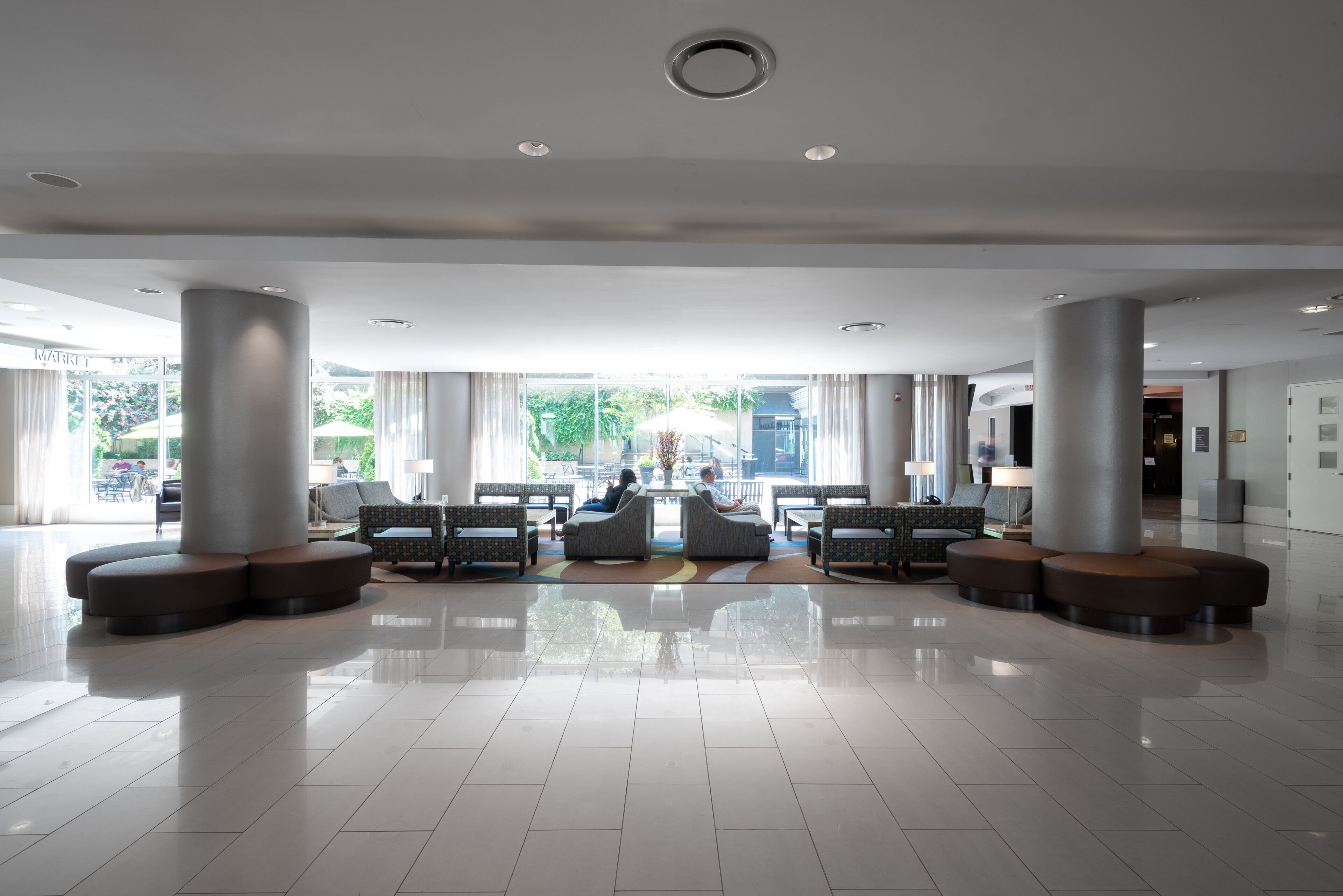 A spacious lobby with a central seating area, large windows, and a clean, modern design.