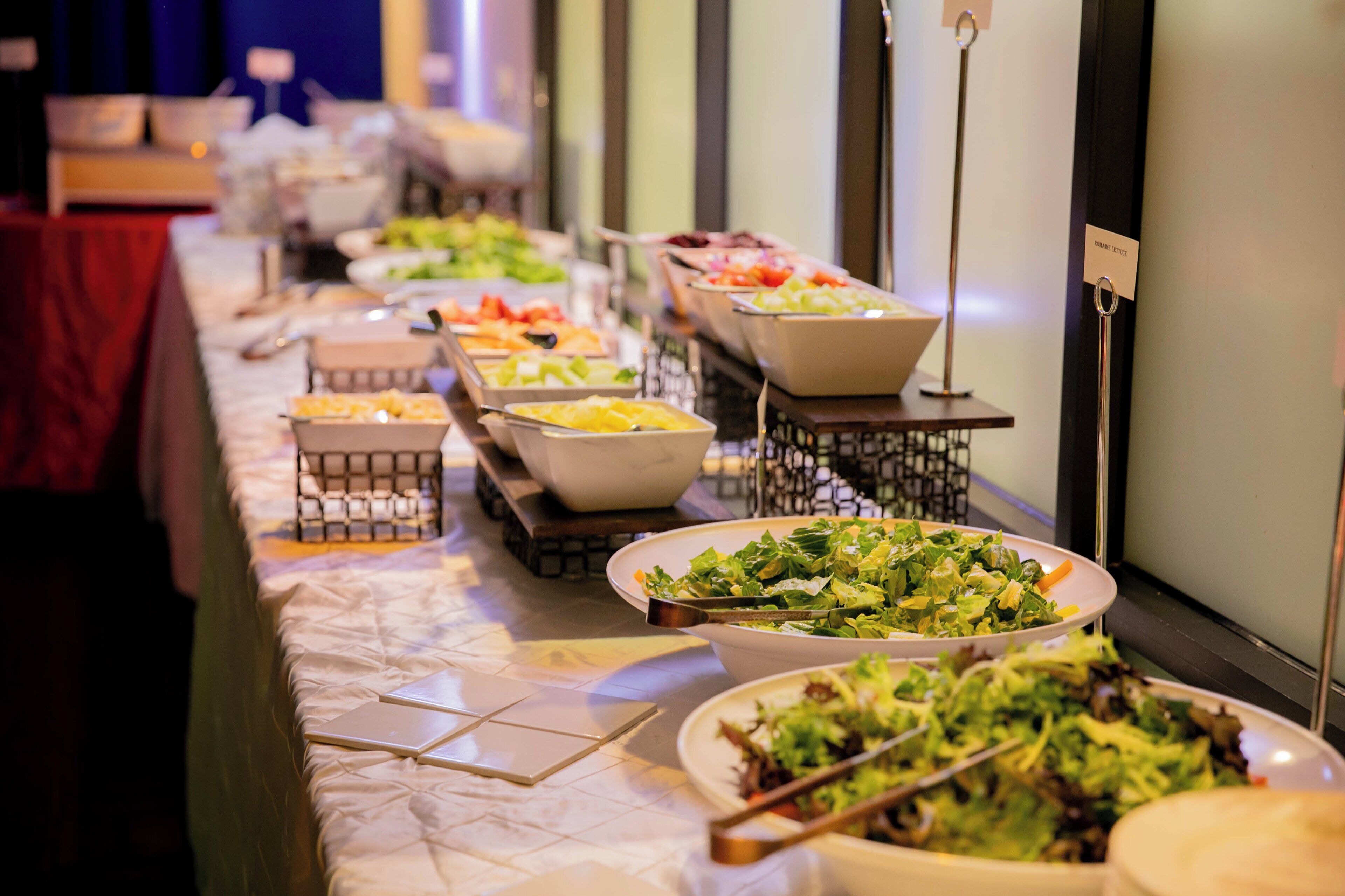 En buffet med forskellige retter og serveringsbestik.