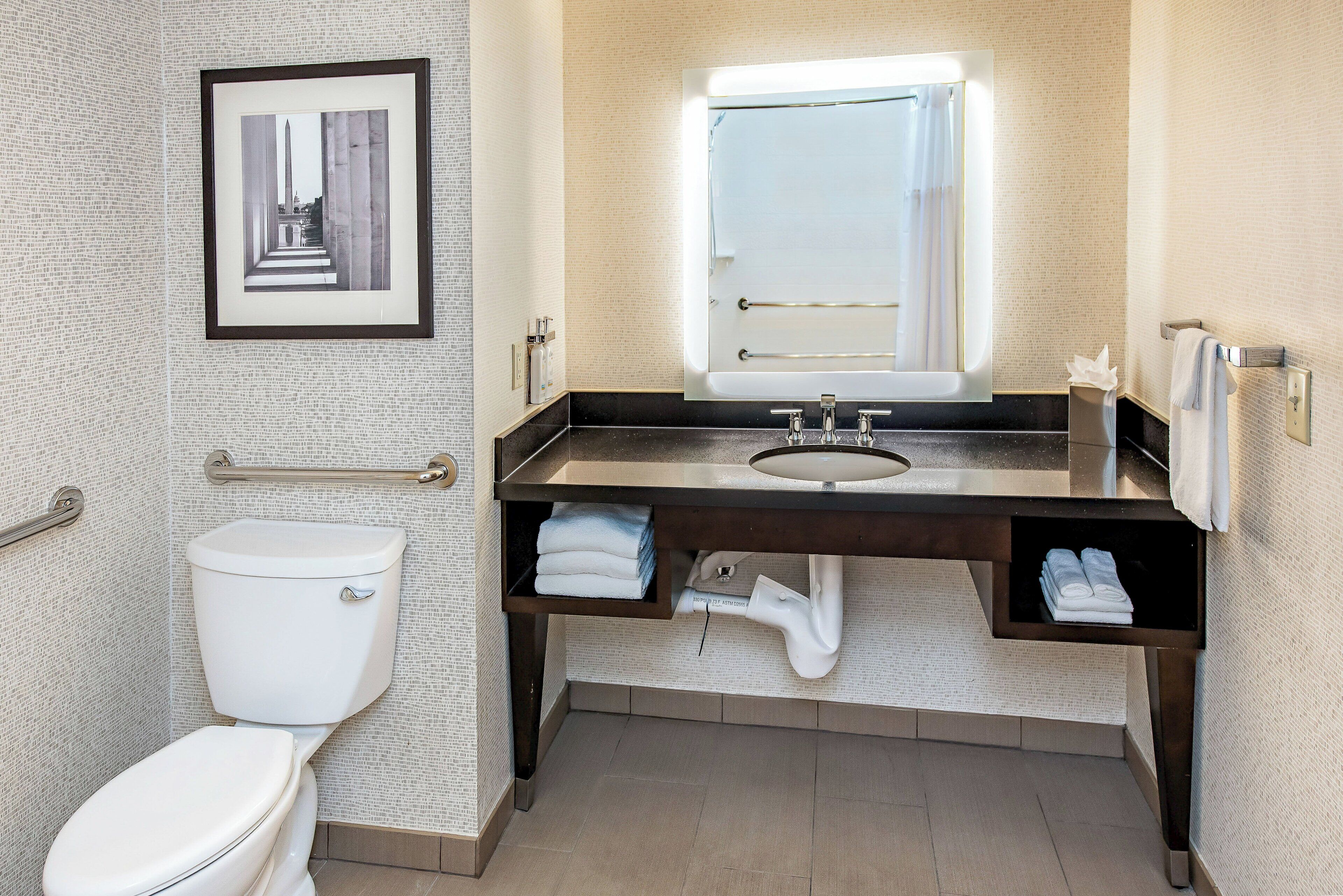 Une salle de bain avec des toilettes, un lavabo et un miroir.