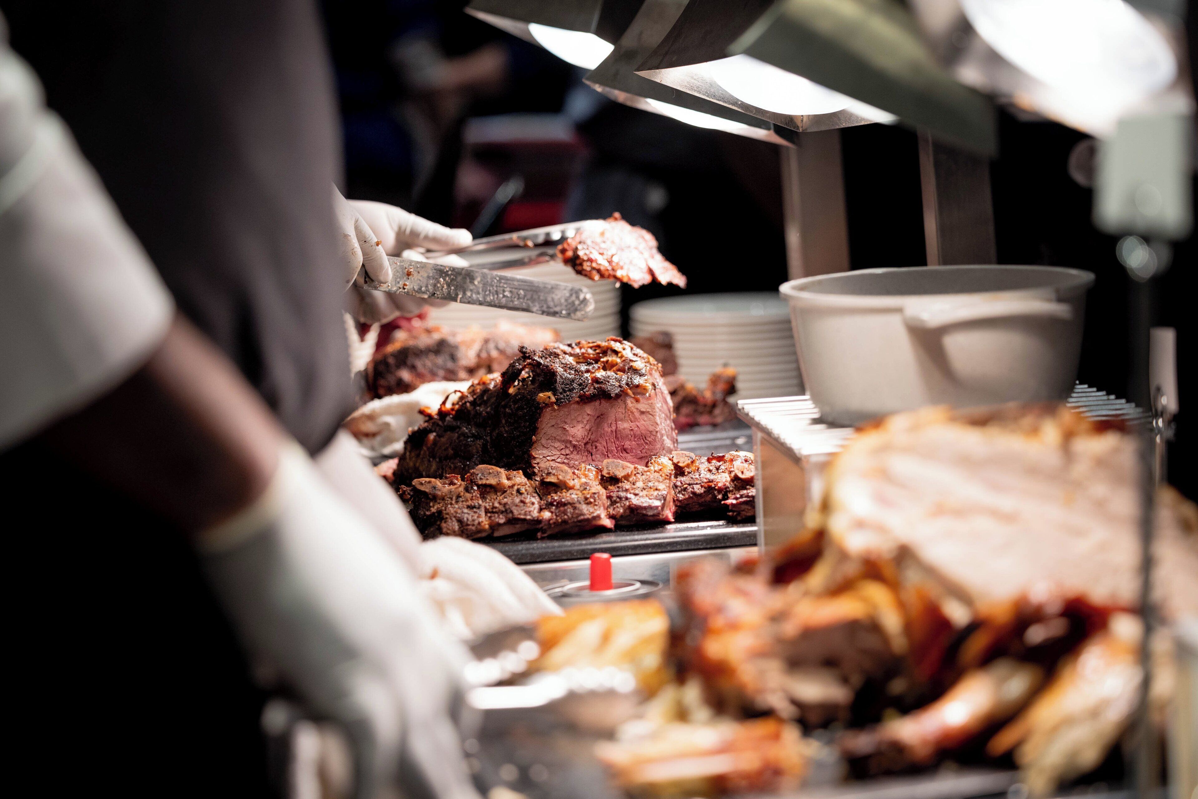 A person serving food from a buffet.