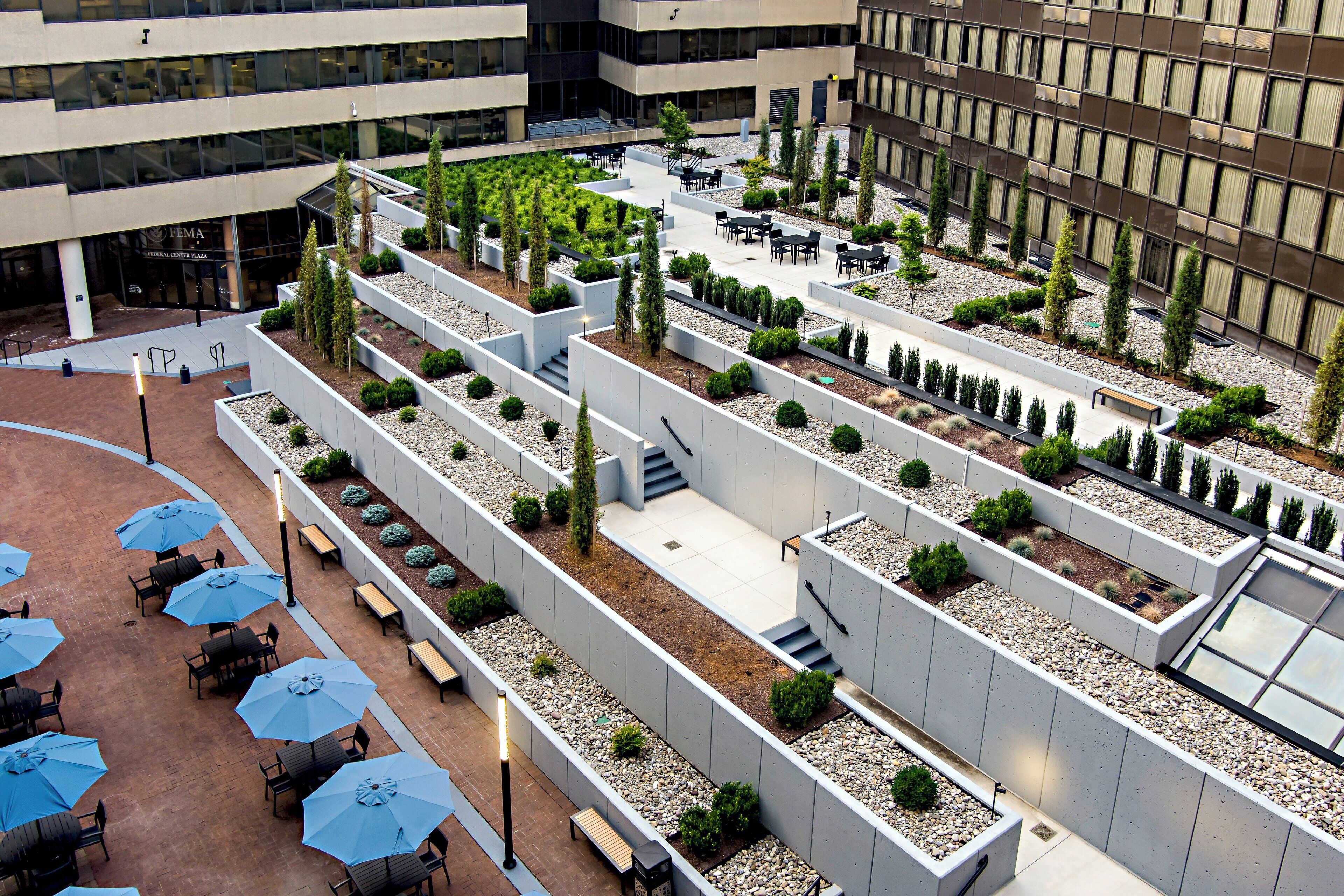 A rooftop garden with seating areas and pathways.
