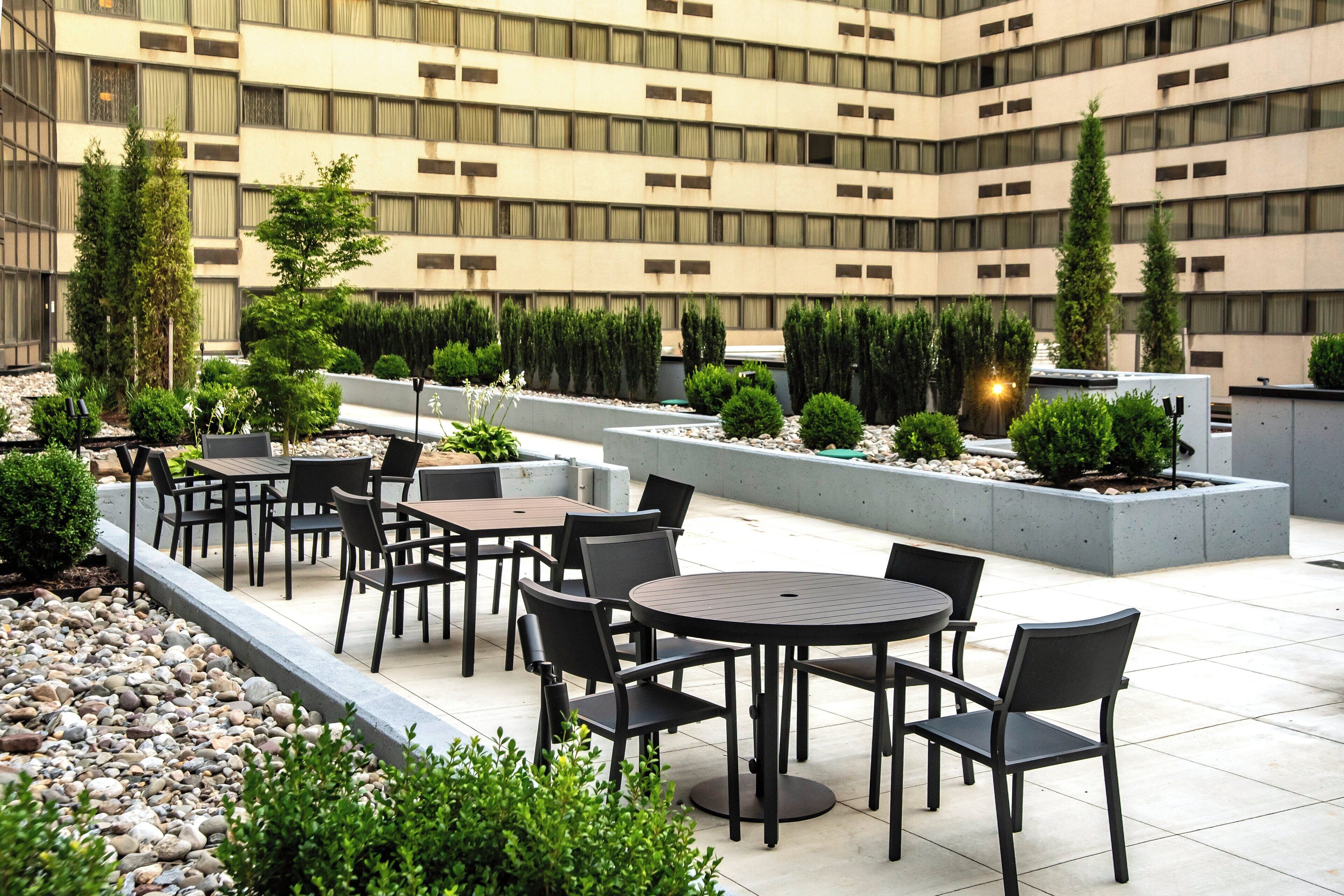 Una terrazza sul tetto con posti a sedere all'aperto e piante.