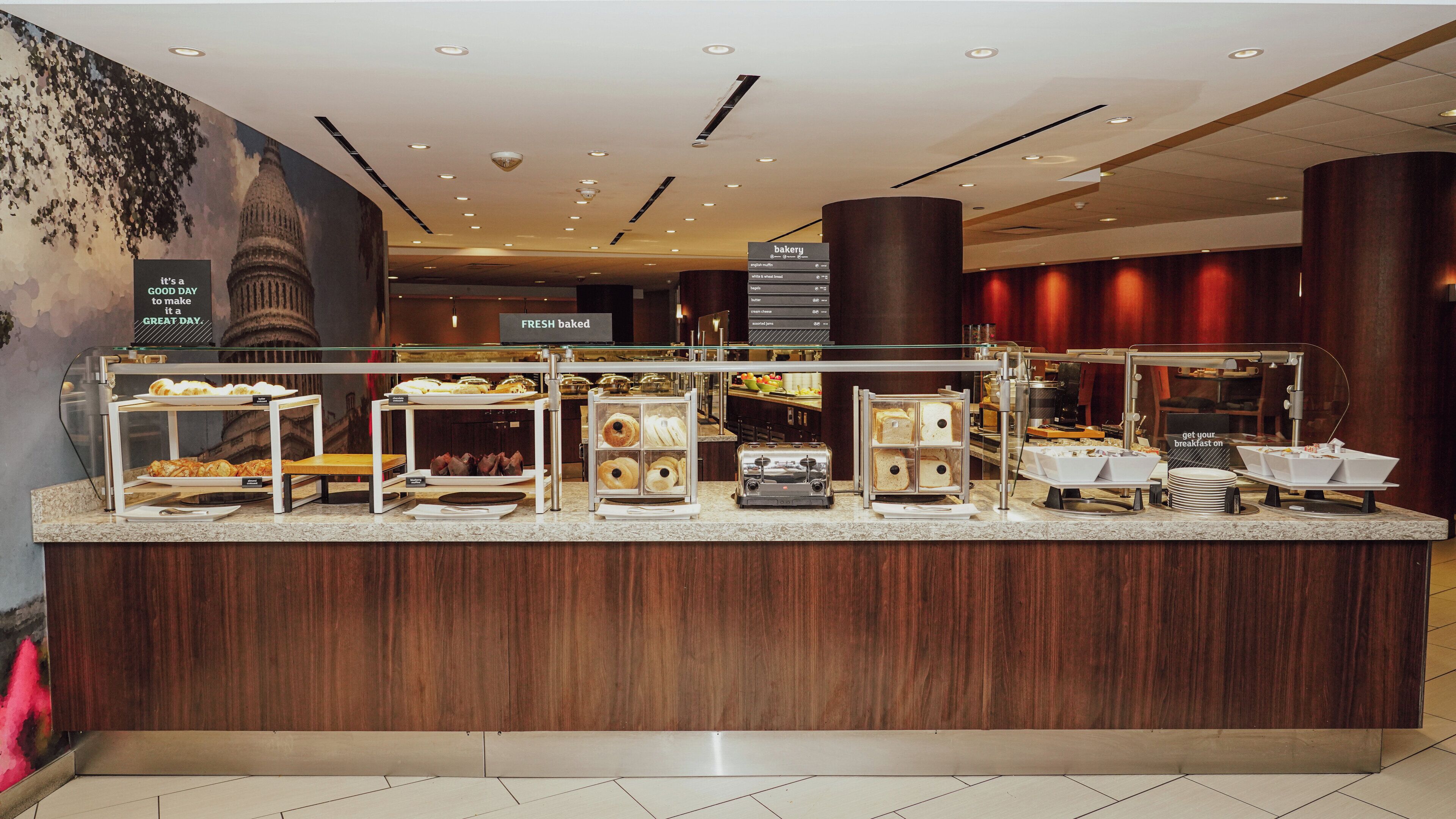 A breakfast buffet with various food items and a sign indicating it's a good day to make it a great day.