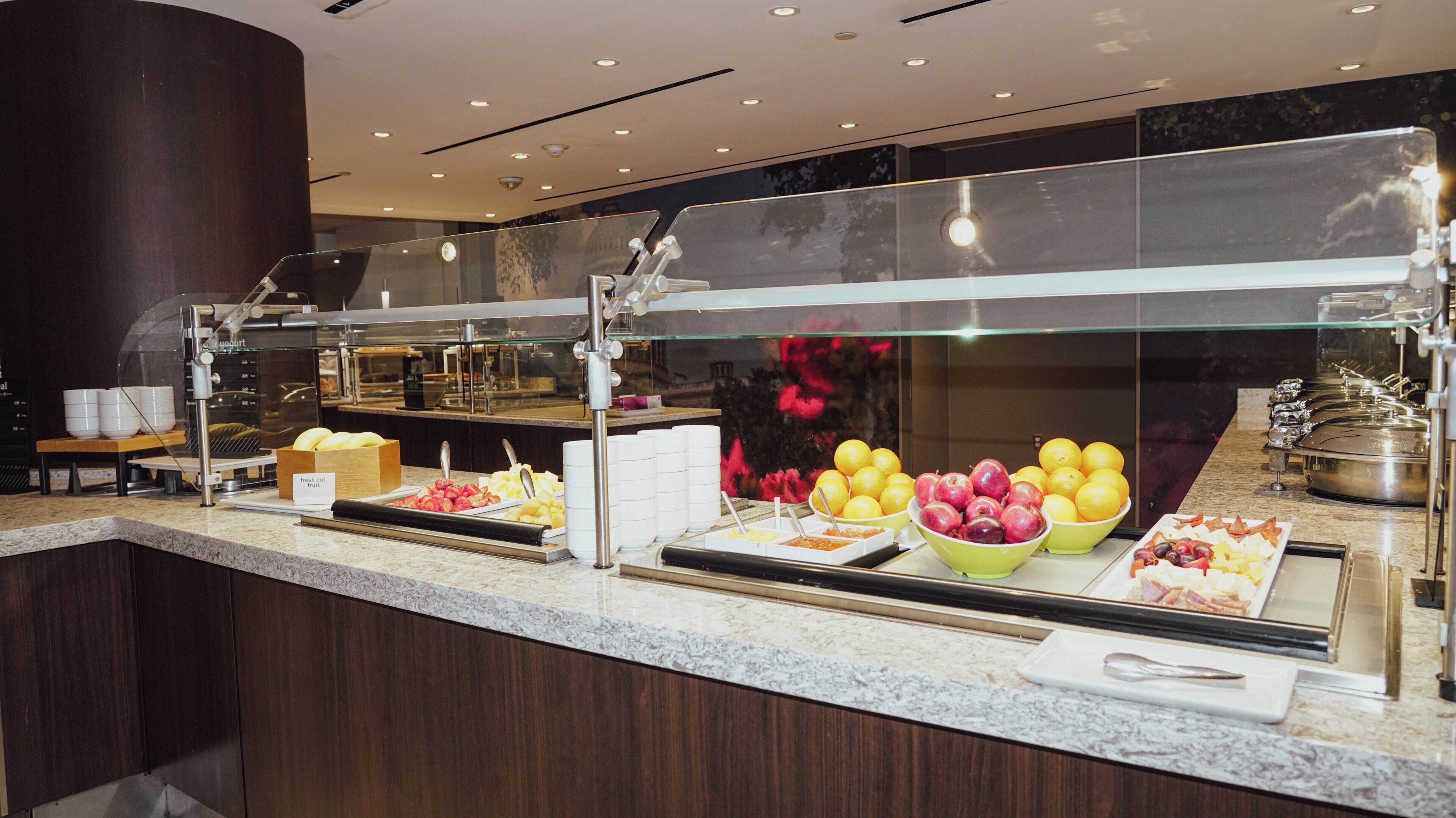 A buffet with various food items and a glass display case.
