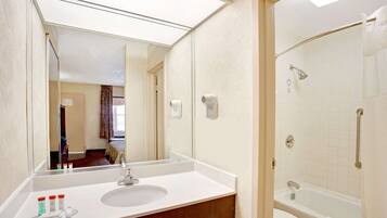 Ein Hotelbad mit einem großen Spiegel, einem Waschbecken und einer Badewanne.
