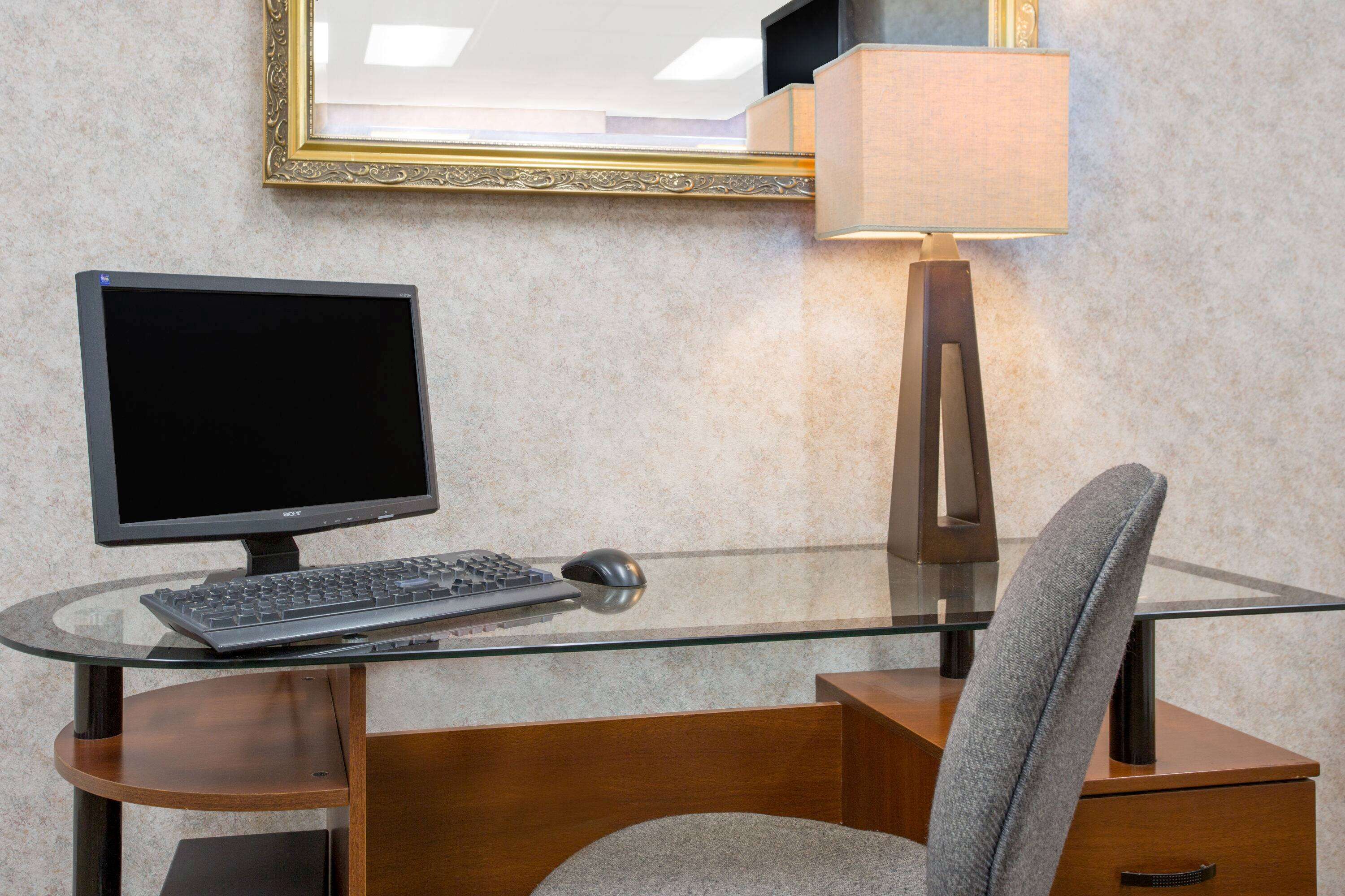A modern office desk with a computer, keyboard, and mouse.