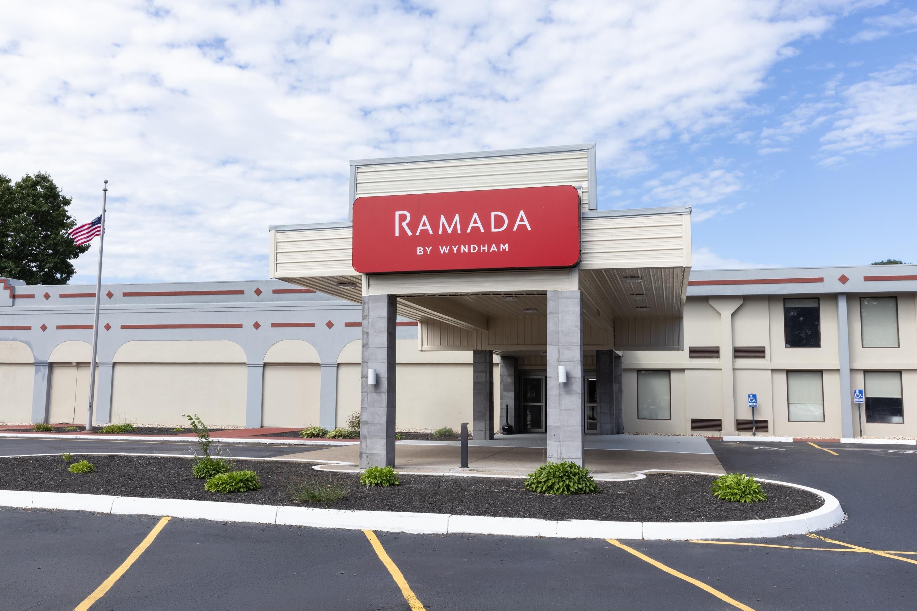Un edificio con un cartel que dice 'RAMADA BY WYNDHAM', indicando un hotel.