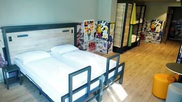 Een hotelkamer met een bed, een tafeltje en een bank.