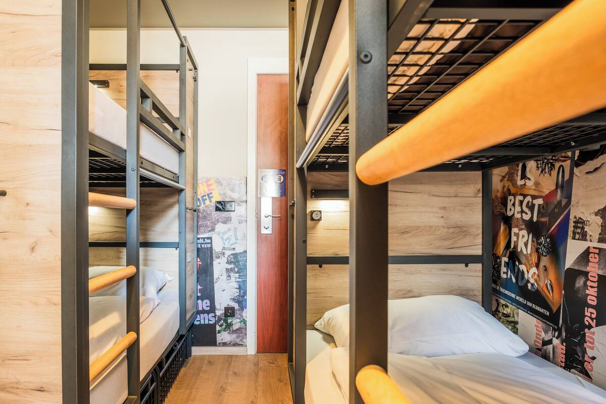A bunk bed room with wooden walls and metal railings.