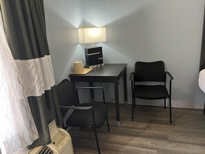 Cozy retreat with a comfortable bed, desk, and reading nook.