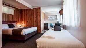 A hotel room with two beds, a kitchenette, and a TV. - Silver Hills Motel (Queenstown)