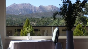 A table set for dining with a mountain view in the background. - Silver Hills Motel (Queenstown)