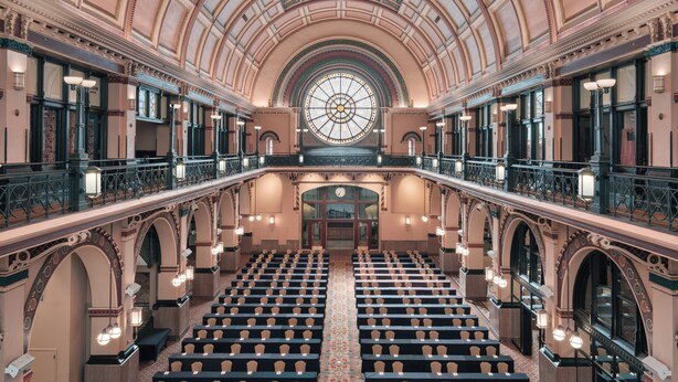 A grand hall with rows of seats, a large circular stained glass window, and ornate architectural details. - Crowne Plaza Indianapolis-Dwtn-Union Stn by IHG (Indianapolis)