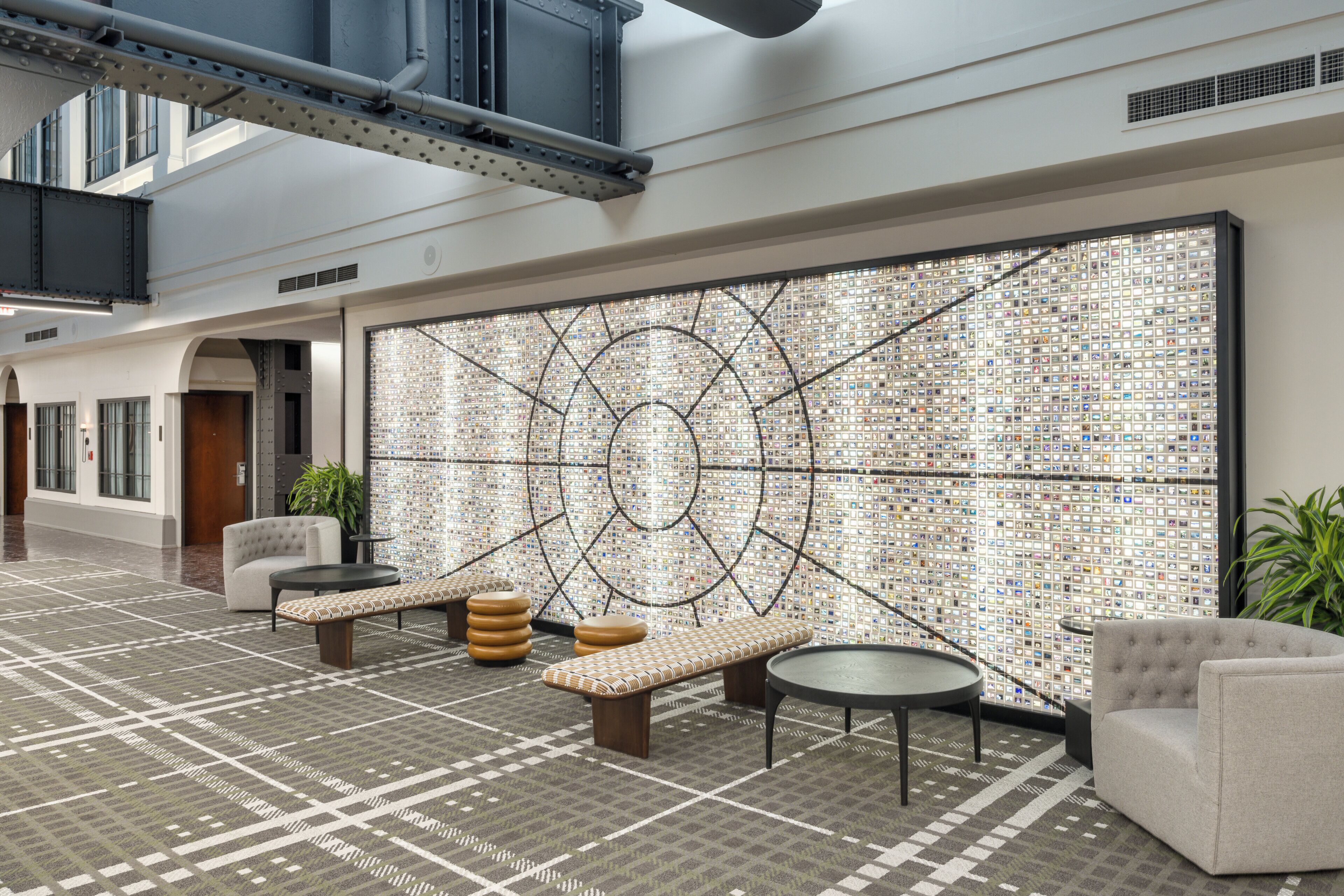 Um hall de entrada com piso estampado, disposição de assentos e parede decorativa com design geométrico.