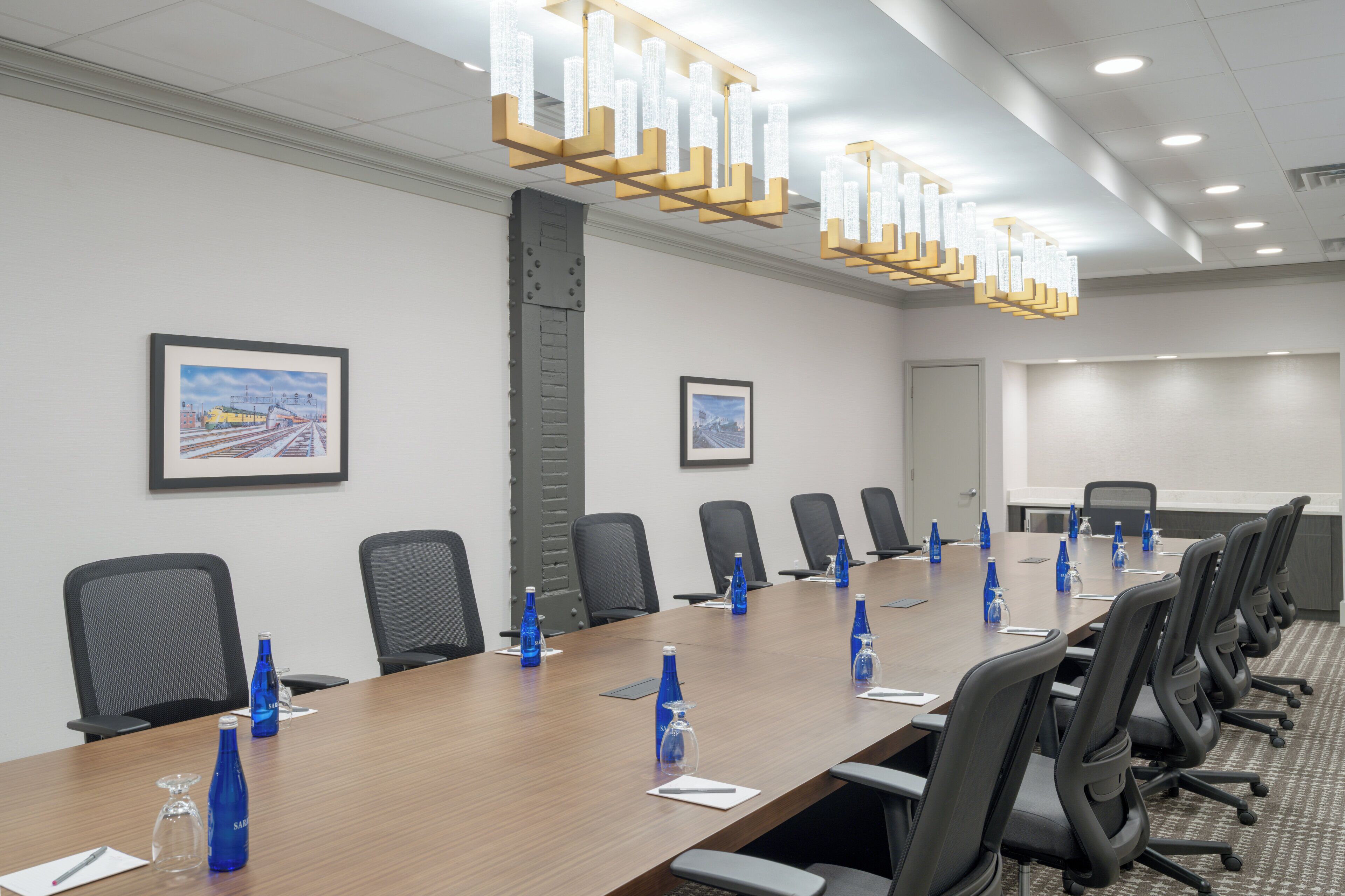 A conference room with a long table, chairs, and blue water bottles.
