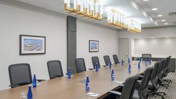 A conference room with a long table, chairs, and blue water bottles.