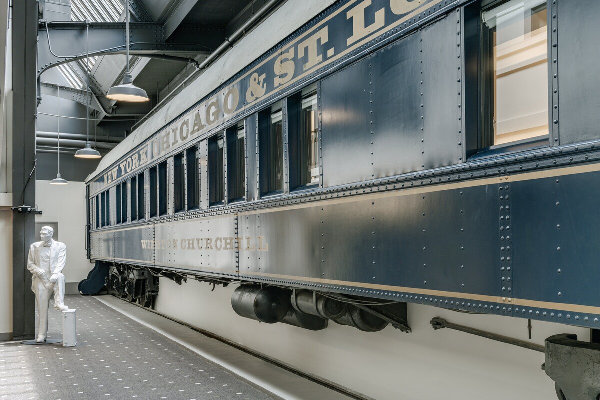 A vintage train car with "NEW YORK OHEIOS & ST. LOUIS" written on the side, located in a train station.