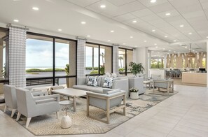 Un hall d’entrée spacieux avec un grand espace salon, un bar et une vue sur l’extérieur.