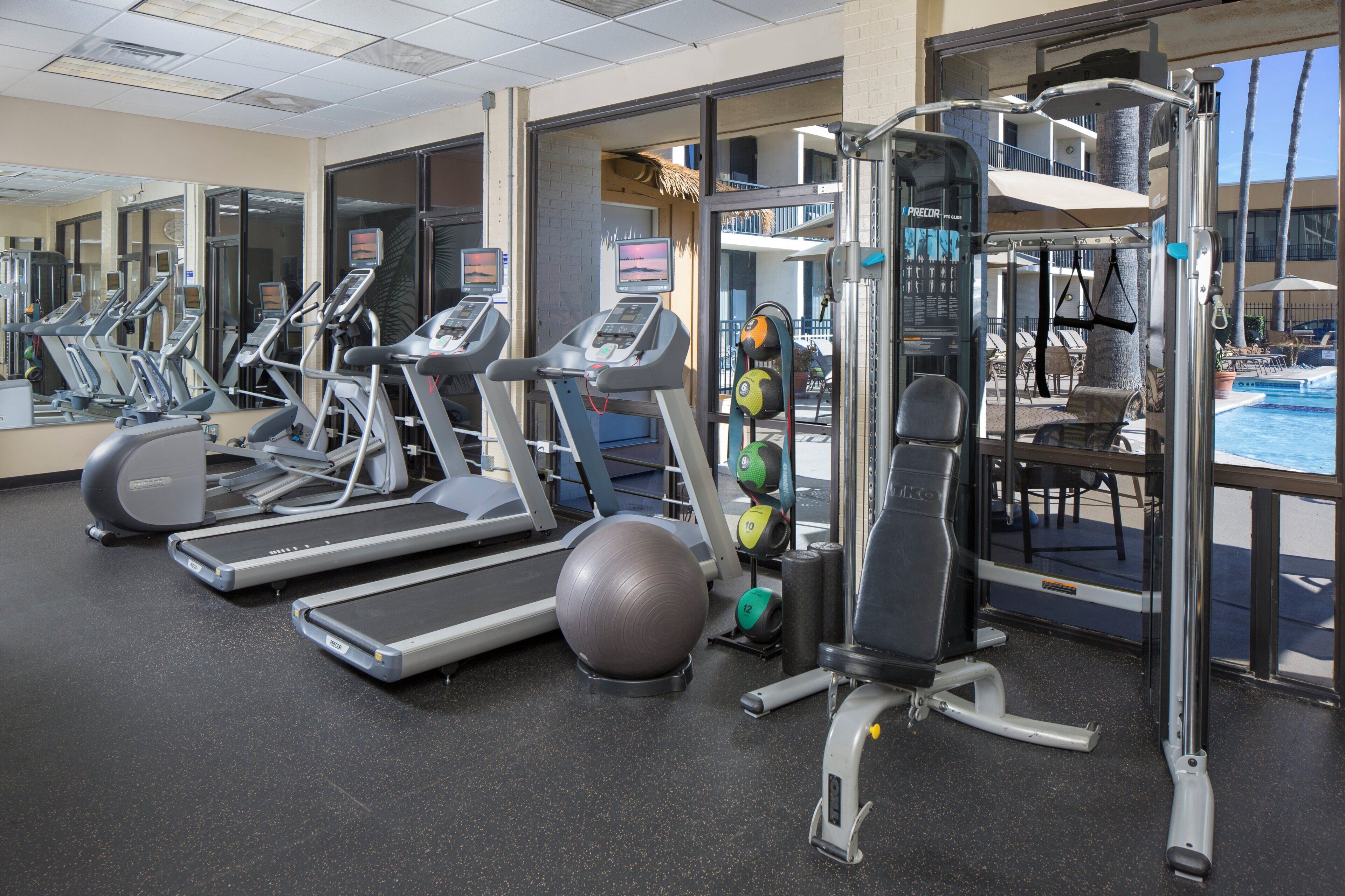 A gym with treadmills, weight machines, and exercise balls.