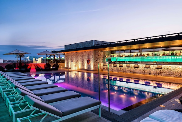 Una piscina al aire libre de temporada, sombrillas