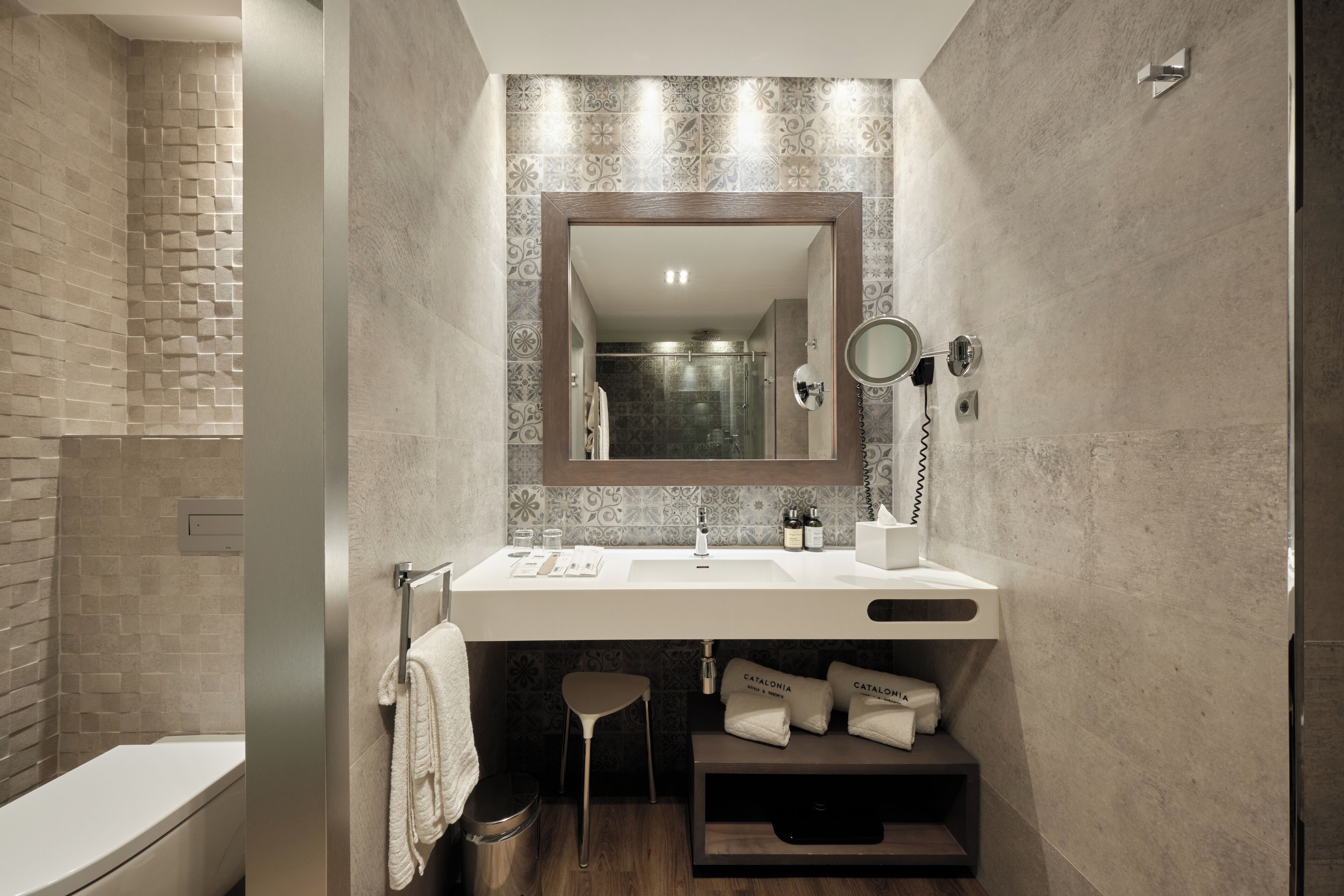 A modern bathroom with a white sink, a mirror, and a towel rack.