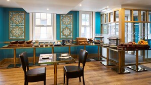 Un espace repas moderne avec un long comptoir, des chaises et une variété d’aliments exposés.