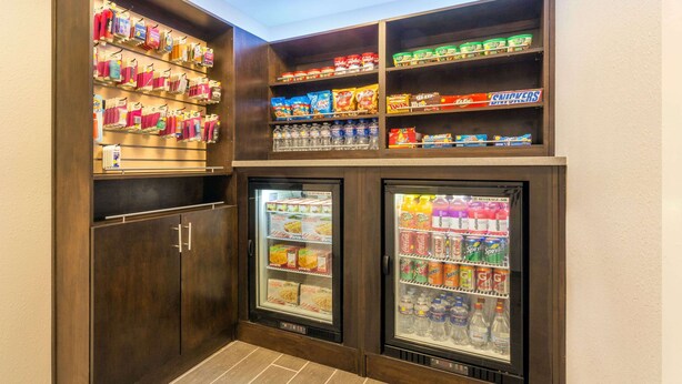 A snack and beverage vending area with multiple shelves stocked with snacks, drinks, and bottled water. - Ramada by Wyndham Monterey (Monterey)