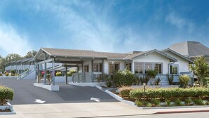 A two-story motel with a covered entrance and a landscaped front yard. - Ramada by Wyndham Monterey (Monterey)