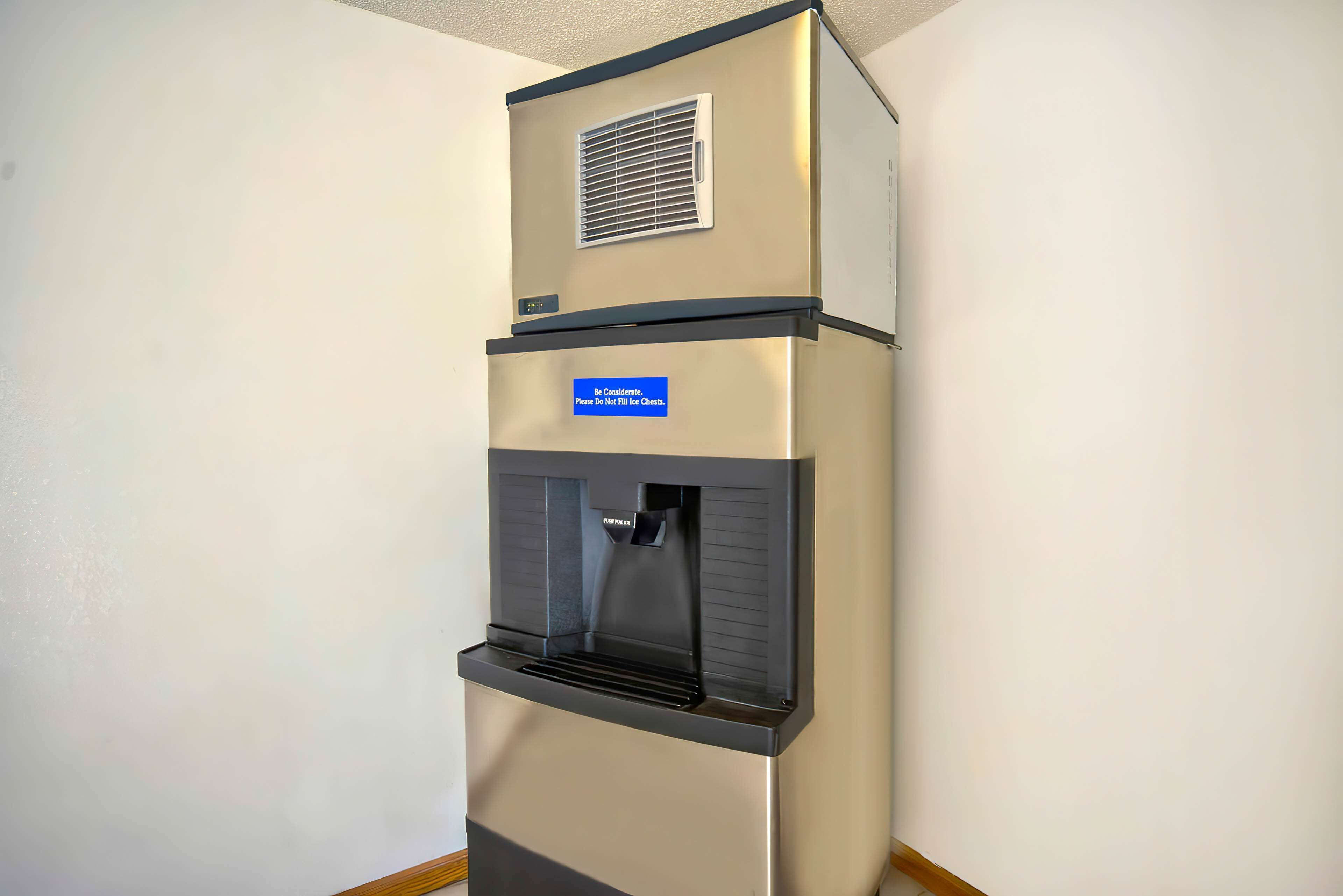 A stainless steel refrigerator with a water dispenser and a vent at the top.