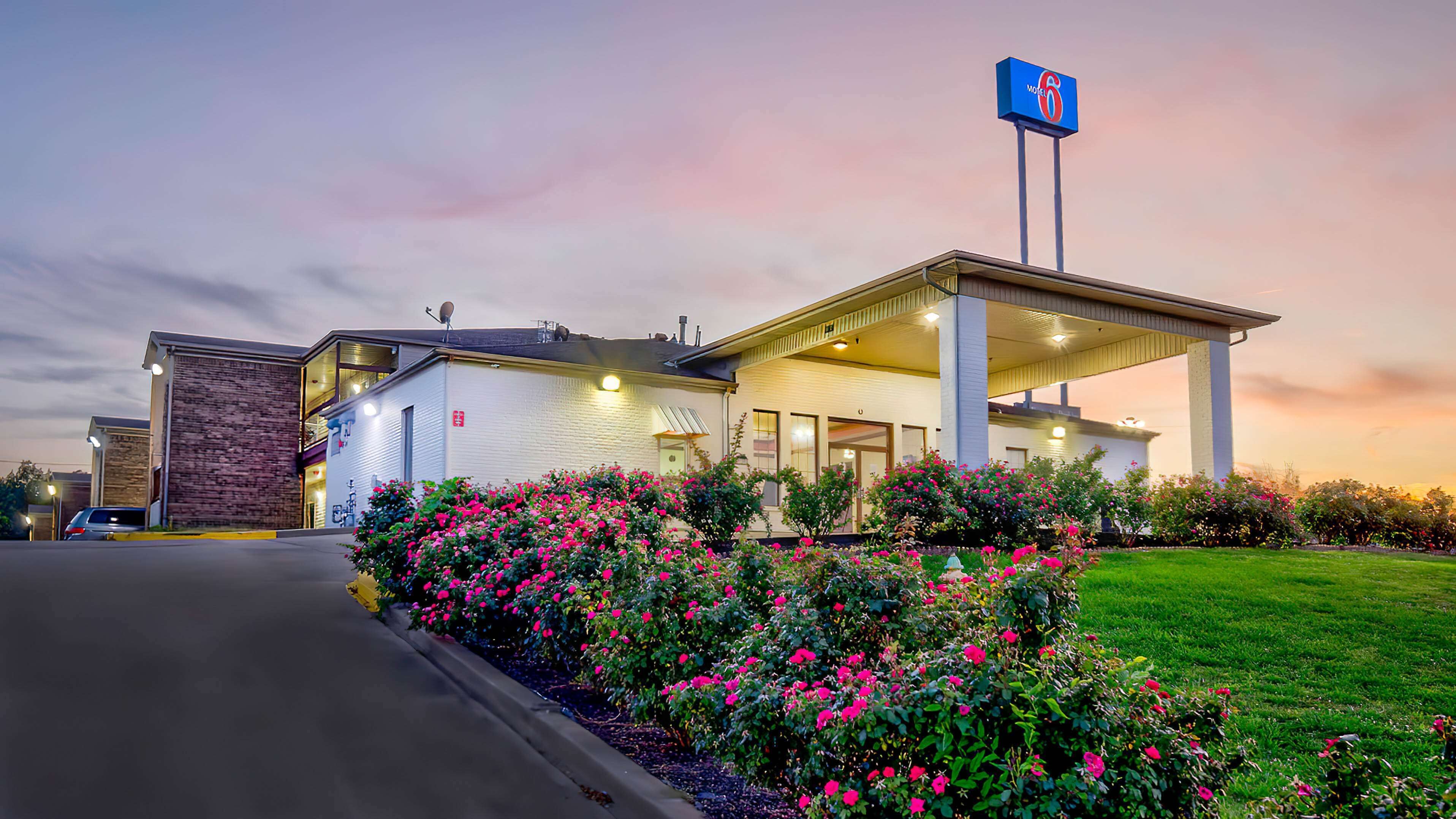 A motel with a brick facade, a covered parking area, and a sign indicating it is a Motel 6.