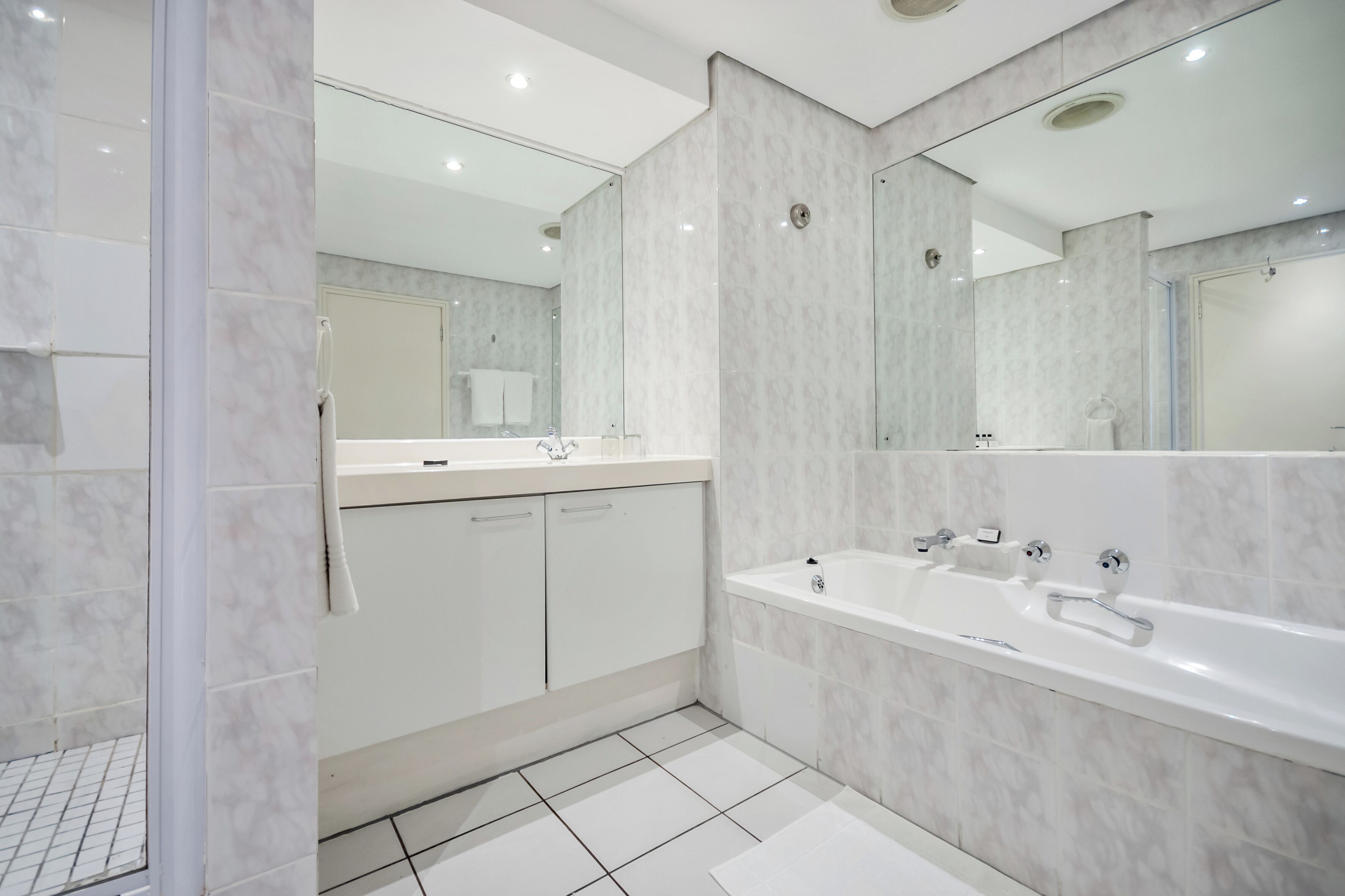 Ein modernes Badezimmer mit einem großen Spiegel, einer Badewanne und einer Duschkabine.