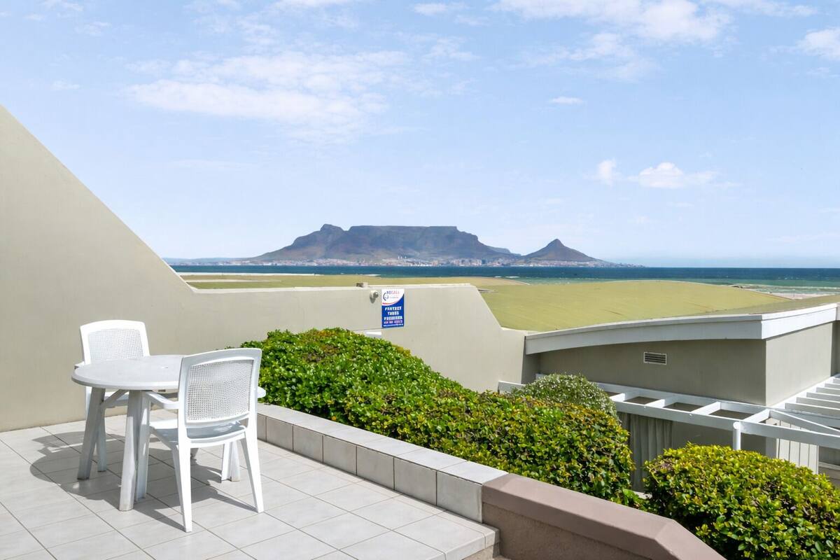Ein Balkon mit weißem Stuhl, Blick auf den Ozean und einem Schild, das einen Privatbereich kennzeichnet.