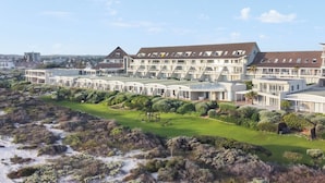 Ein modernes Hotel mit mehreren Gebäuden, einem gepflegten Rasen und Blick auf die umliegende Landschaft.