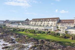 Ein modernes Hotel mit mehreren Gebäuden, einem gepflegten Rasen und Blick auf die umliegende Landschaft.