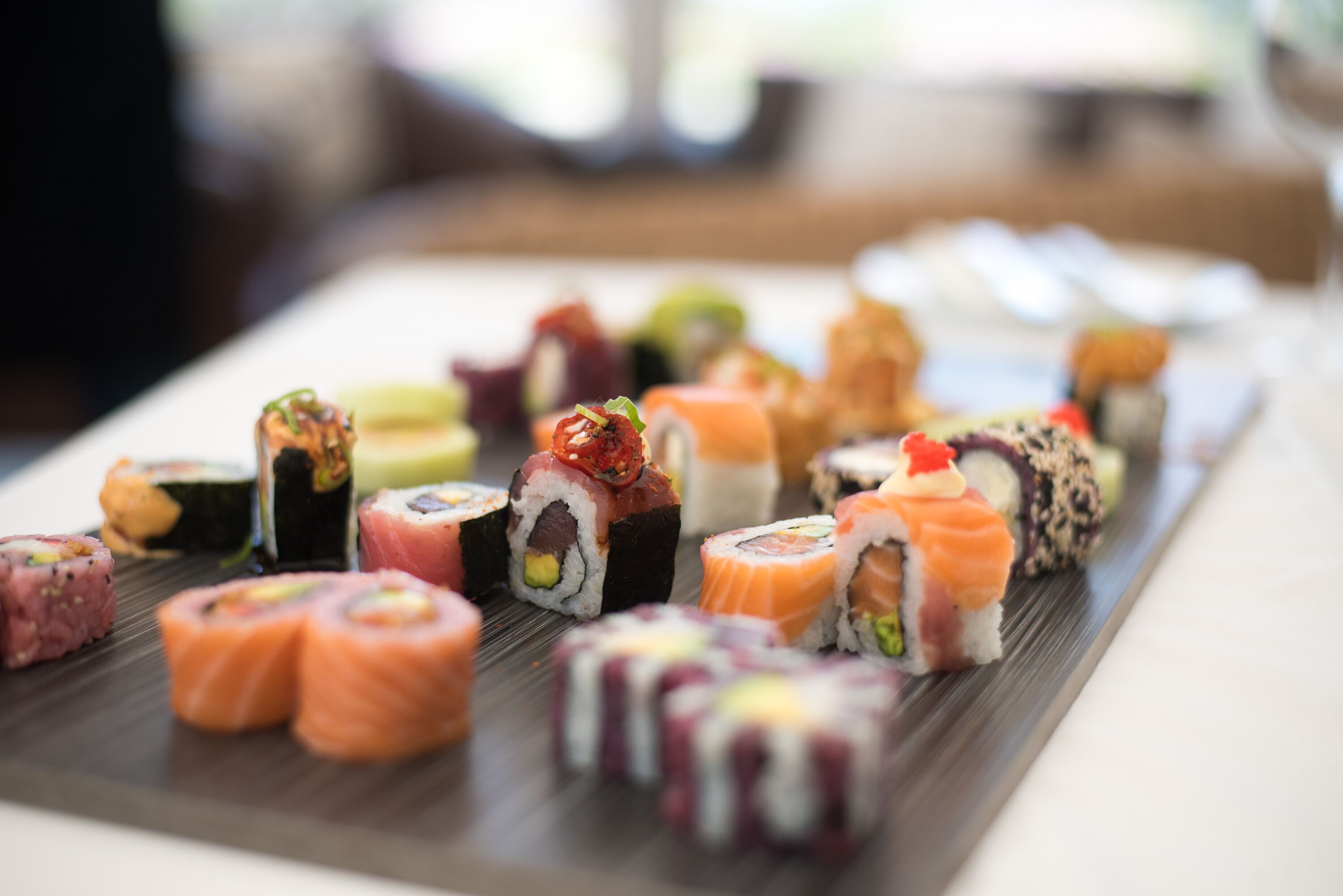 A variety of sushi on a wooden tray.