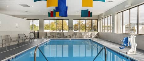 A swimming pool with chairs and a lifeguard stand.