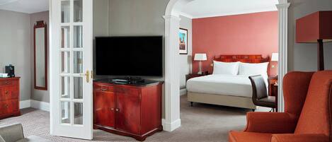 A hotel room with a bed, a television, a desk, and a chair.