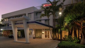 Un hôtel Hilton Garden Inn au design moderne, doté d’une entrée abritée, de nombreux balcons et d’un aménagement paysager luxuriant.