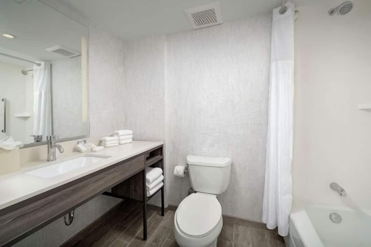 A modern bathroom with a white sink, toilet, and bathtub.